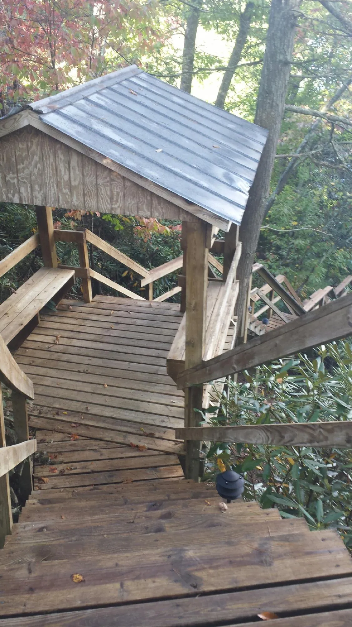 Metal roofed shelter over wooden steps on a wooded walkway — Skylight Repair & Installation work by our crew in Harmans